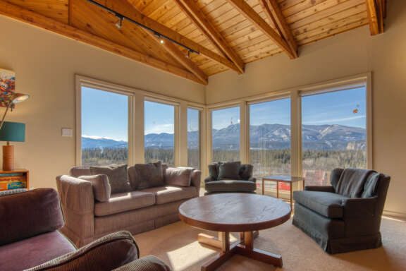 Eclectic living area with large windows framing the mountain views