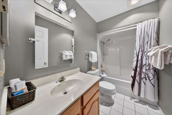 Second bathroom with tub and shower combo, vanity, and mirror at Tee House 3BR-13 in Mountain View Villas