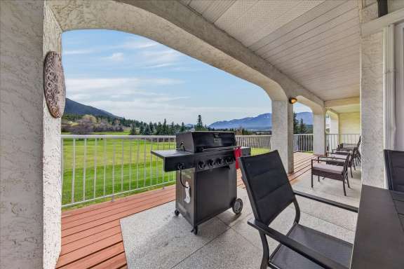 Covered deck with gas BBQ and lounge seating at Tee House 3BR-13 in Mountain View Villas