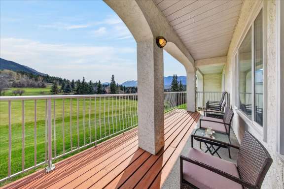 Partially covered deck with lounge seating, gas BBQ and golf course and mountain views at Tee House 3BR-13 in Mountain View Villas