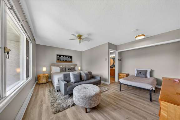Master bedroom with king bed, seating area, Smart TV and hideaway twin bed set up at Tee House 3BR-13 in Mountain View Villas