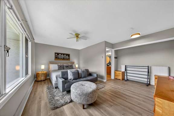 Master bedroom with king bed, seating area, Smart TV and hideaway twin bed stored away at Tee House 3BR-13 in Mountain View Villas