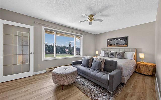 Living room with electric fireplace, Smart TV, golf course and mountain views at Tee House 3BR-13 in Mountain View Villas.