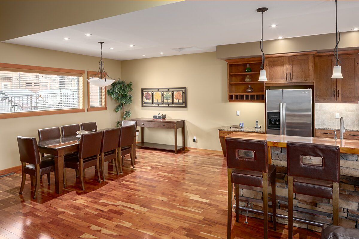 Kitchen and dining areas. Large dining room table and kitchen area with island, barstool and appliances.