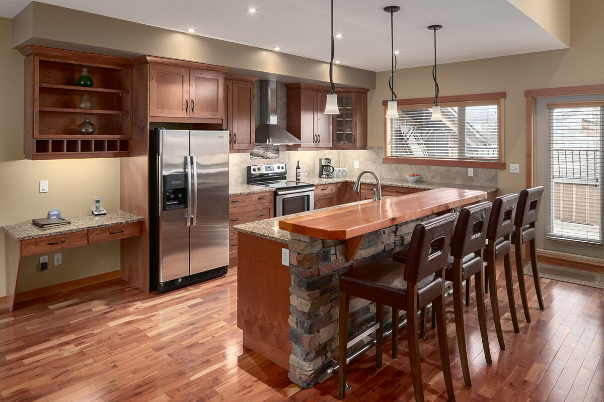 Spacious kitchen with island, four barstools and appliances.