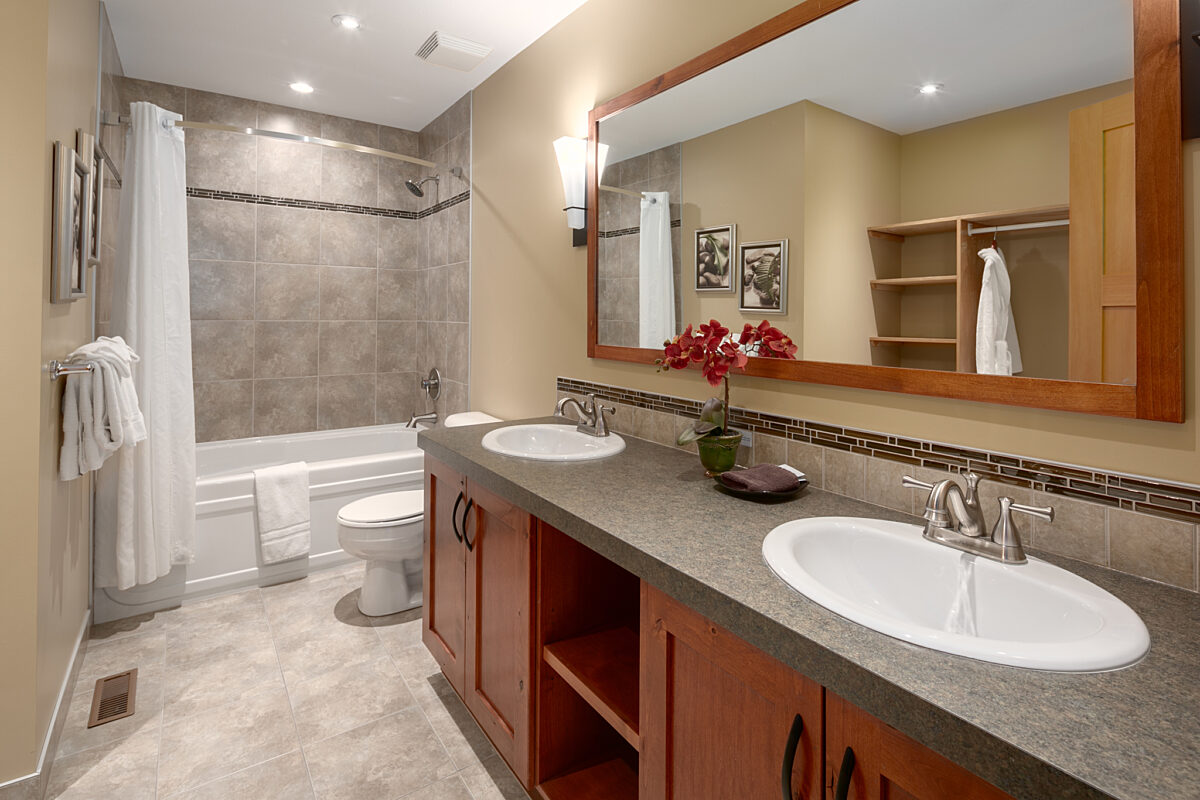Ensuite bathroom with double sinks, large shower to the left, and vanity.