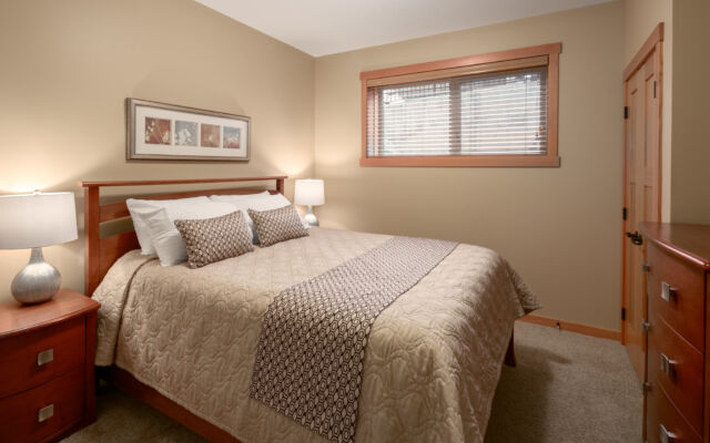Living space with couches, television, and window to the left. Tall ceilings.