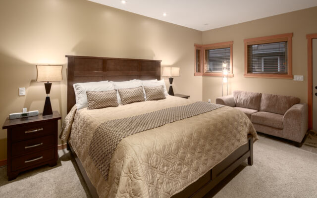 Living space with couches, television, and window to the left. Tall ceilings.