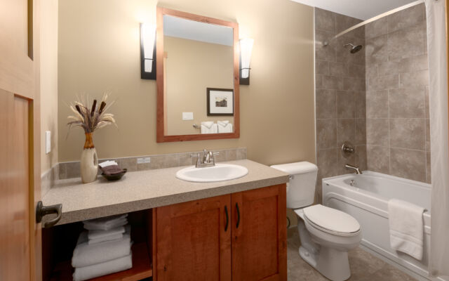 Living space with couches, television, and window to the left. Tall ceilings.