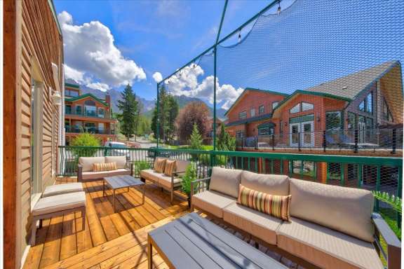 Expansive wrap-around upper deck with comfortable outdoor lounge seating, mountain views and surrounding vacation homes at Springs & Swings - Marble Canyon 504 - Phase 1