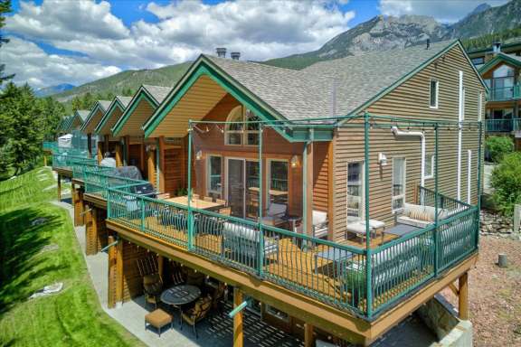 Exterior view of Springs & Swings - Marble Canyon 504 - Phase 1, a three-level end-unit townhome with expansive wrap-around decks overlooking the Mountainside Golf Course in Fairmont Hot Springs.