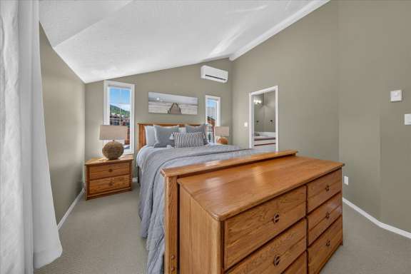 Bright master bedroom with a queen bed, twin bed, air conditioning, bedside tables, dresser and private ensuite bathroom in a Fairmont Creek vacation rental