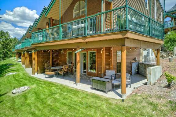Covered lower deck with comfortable patio seating, a fire table and outdoor living space beneath the upper wrap-around deck at Springs & Swings - Marble Canyon 504 - Phase 1.