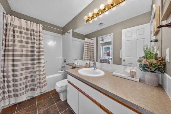 Main-level Jack & Jill bathroom with a vanity, shower over tub, and hallway access in Springs & Swings - Marble Canyon 504 - Phase 1.