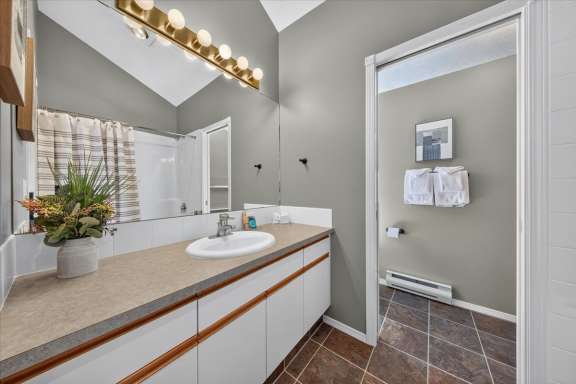 Private ensuite bathroom with a vanity, shower over tub, and separate toilet area adjoining the primary bedroom at Springs & Swings - Marble Canyon 504 - Phase 1