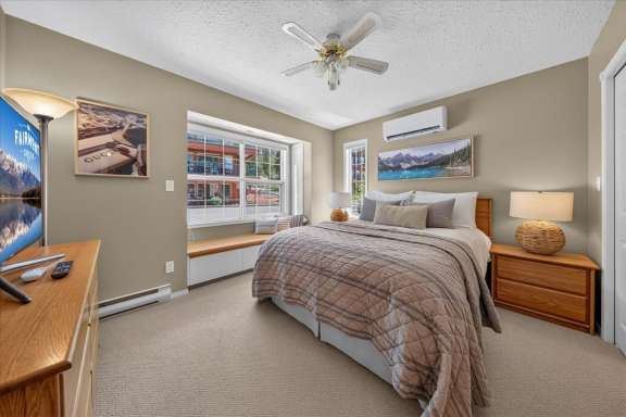 Main-level bedroom with a queen bed, Smart TV, air conditioning, large window seat, and Jack & Jill ensuite access in Springs & Swings - Marble Canyon 504 - Phase 1