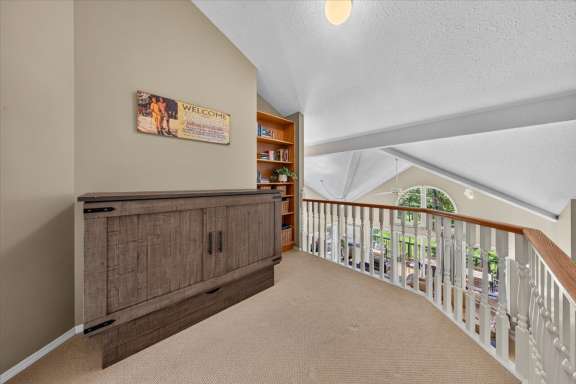 Open landing overlooking the living room with a queen cabinet bed, built-in bookshelf, books, games, and additional sleeping space at Springs & Swings - Marble Canyon 504 - Phase 1.