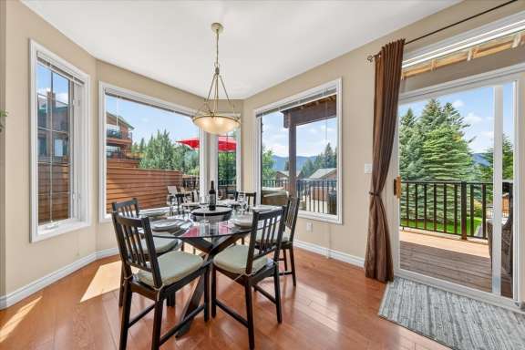 Dining area at Marble Canyon 704 Phase 2 featuring a table for six, large windows, mountain views, and direct access to the outdoor deck and BBQ area.