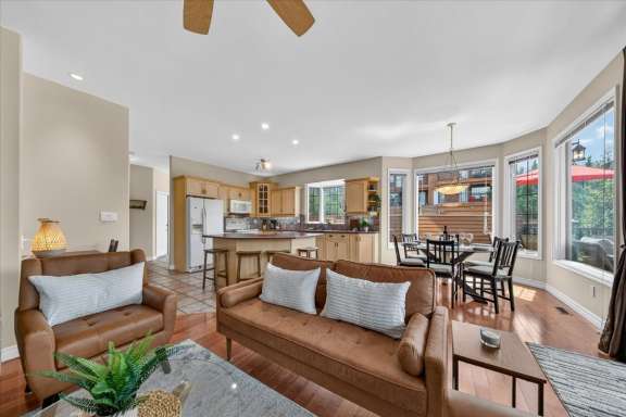 Open-concept living room, dining area and fully equipped kitchen with breakfast bar seating at Marble Canyon 704 Phase 2 in Fairmont Hot Springs.