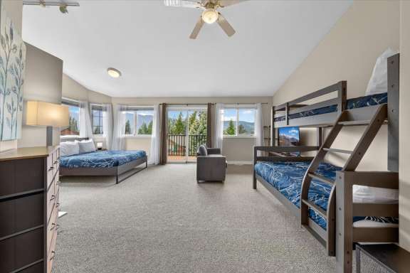 Second bedroom with queen bed, twin-over-double bunk bed, Smart TV, private balcony and mountain views at Marble Canyon 704 Phase 2 in Fairmont Hot Springs.