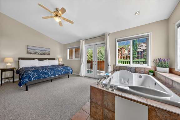 Master bedroom with king bed, in-room jacuzzi tub, private balcony and mountain views at Marble Canyon 704 Phase 2 in Fairmont Hot Springs.