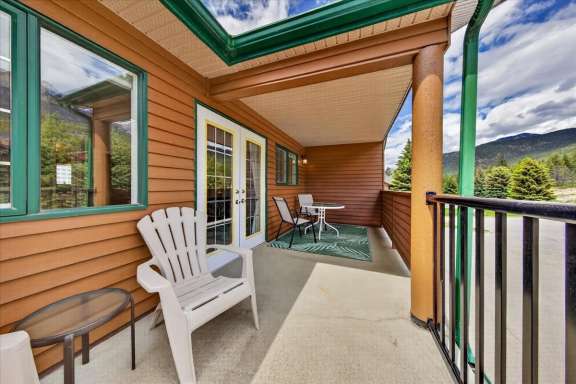 Private balcony off the master bedroom with outdoor seating, dining table and mountain views at Marble Canyon 704 Phase 2 in Fairmont Hot Springs.