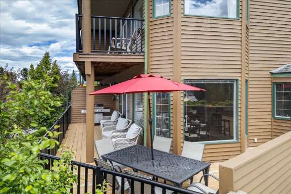 Large wrap around deck with outdoor dining table, lounge seating and gas BBQ at Marble Canyon 704 Phase 2 in Fairmont Hot Springs.