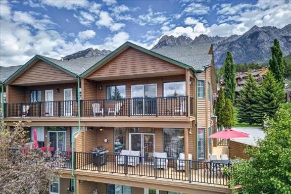 Exterior of Marble Canyon 704 Phase 2 showcasing the large deck, private balconies, and stunning mountain views in Fairmont Hot Springs.