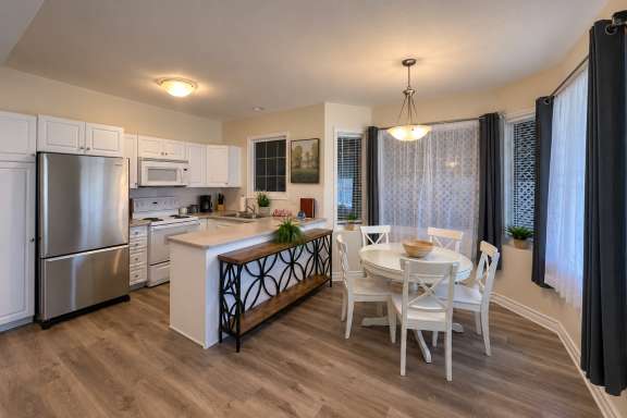 Open-concept kitchen and dining area at Little Falls Landing with full-size appliances, ample counter space and dining table