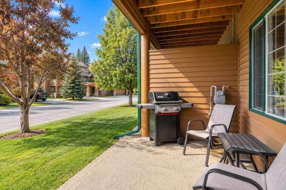Covered patio at Little Falls Landing with BBQ, outdoor seating and table overlooking the surrounding grounds