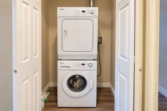In-suite laundry area at Little Falls Landing with a stacked washer and dryer
