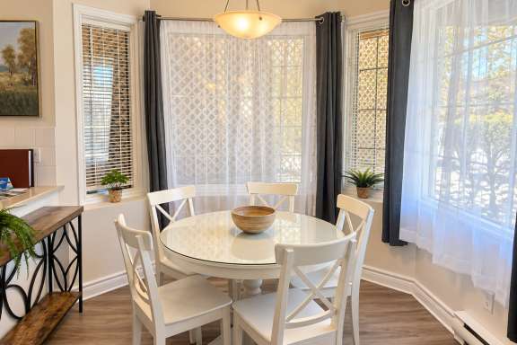 Bright dining area at Little Falls Landing with a round table, seating for 5 and large windows providing plenty of natural light