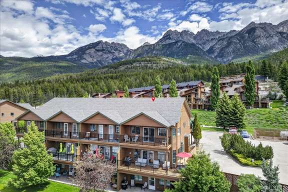 Exterior view of the Marble Canyon townhomes with Little Falls Landing located on the ground level and the Rocky Mountains in the background