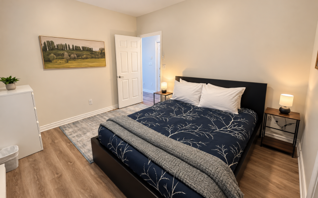 Comfortable living room at Little Falls Landing with sofa, armchair, coffee table, TV, double hide-a-bed and large windows.