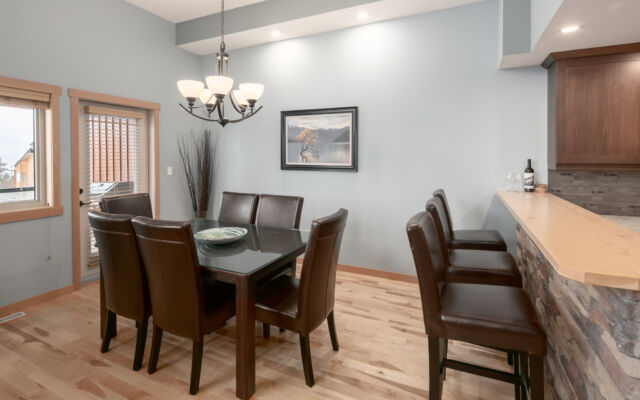 Large living room with windows to the right. Television above, two couches, one chair and coffee table.