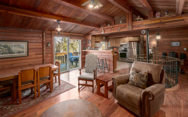 Quaint wood cabin surrounded by greenery and trees.