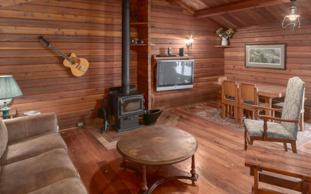 Quaint wood cabin surrounded by greenery and trees.