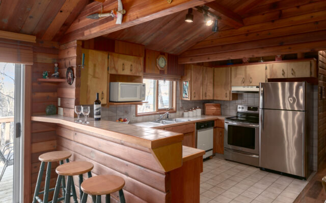 Quaint wood cabin surrounded by greenery and trees.