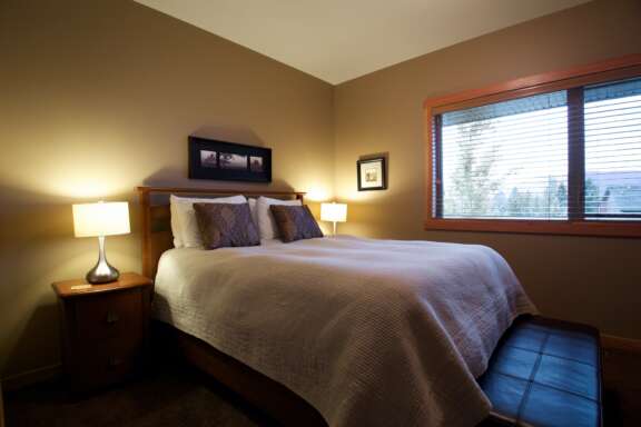 Master bedroom with king bed. Night tables with lamp on each side.