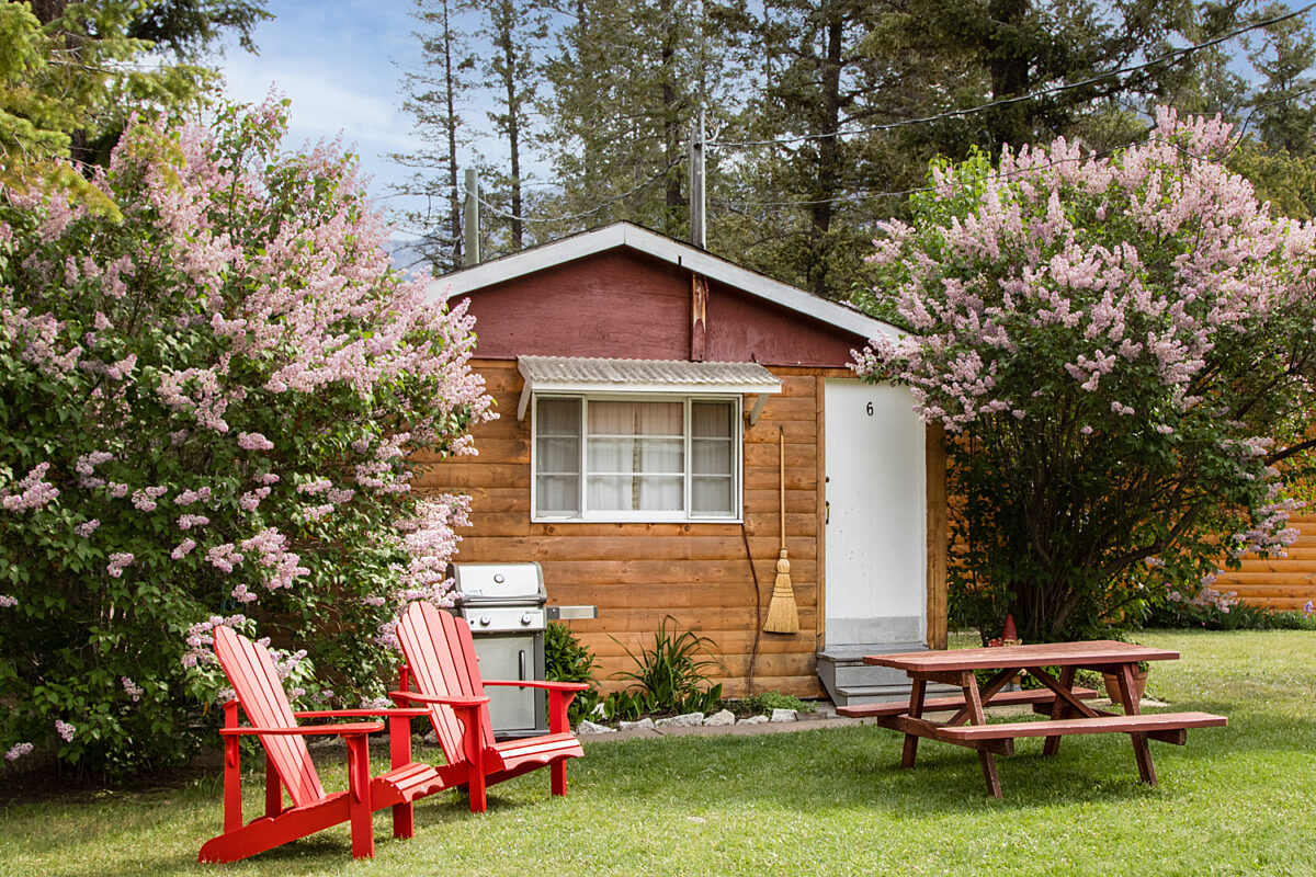 Outdoor living space with two red chairs and teal swing.