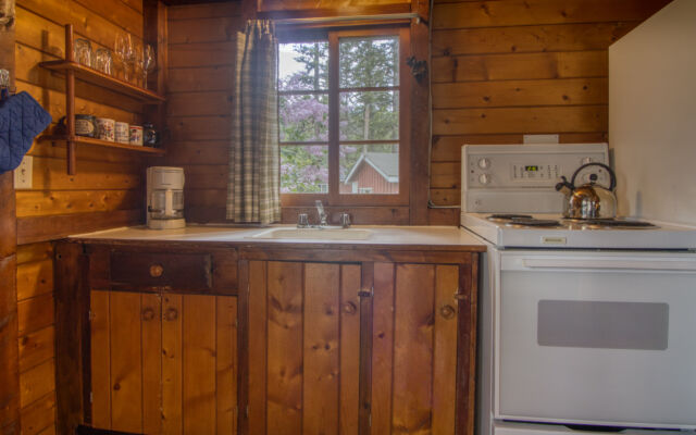 Outdoor living space with two red chairs and teal swing.