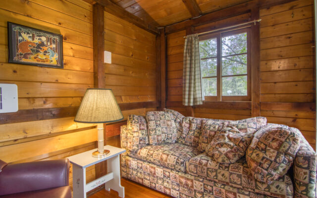 Outdoor living space with two red chairs and teal swing.