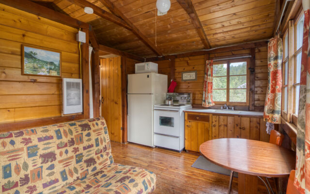 Outdoor living space with two red chairs and teal swing.
