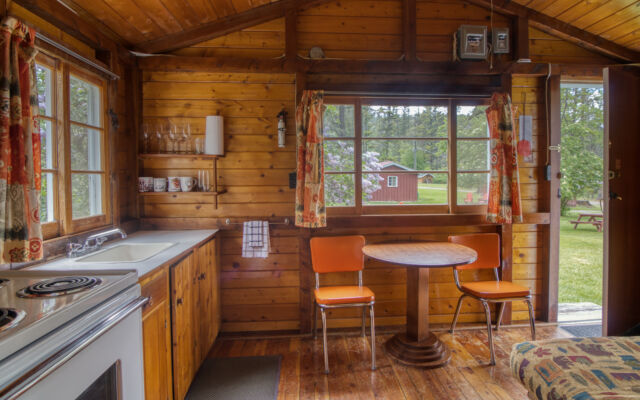 Outdoor living space with two red chairs and teal swing.