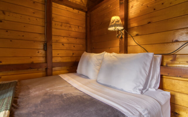 Outdoor living space with two red chairs and teal swing.