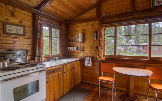 Outdoor living space with two red chairs and teal swing.