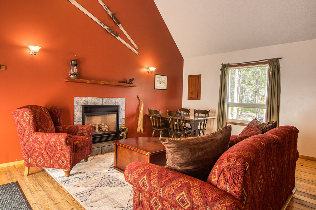 Living room with red chairs, fireplace, and window to the right.