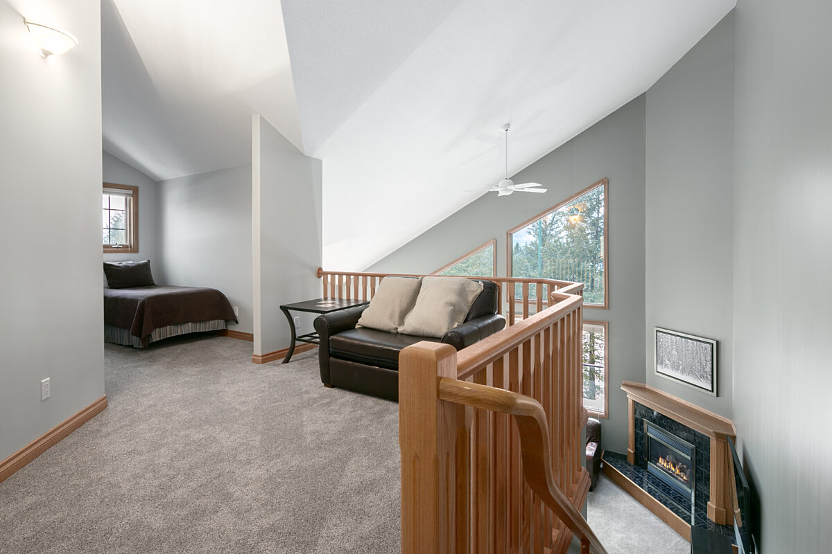 Loft area overlooking living space. To the left, bedroom and bed. Couch overlooking loft.