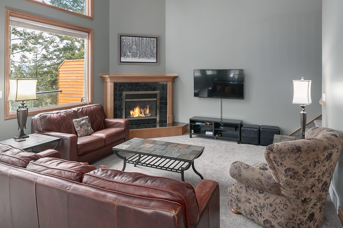 Living room area with two red leather couch, chair, coffee table, and television