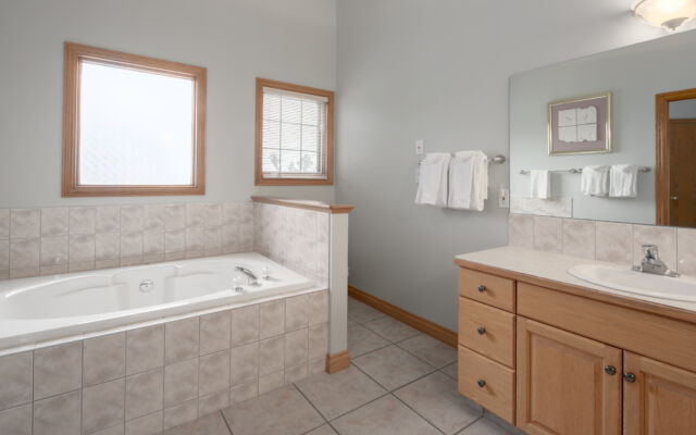 Living room area with two red leather couch, chair, coffee table, and television